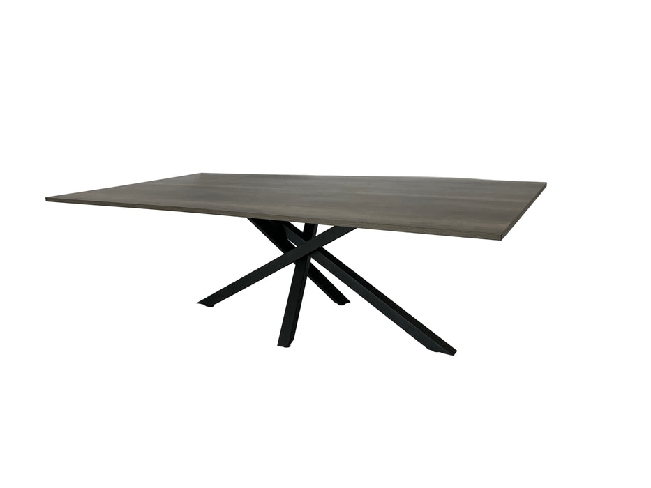 Modern dining table with wooden top and black metal legs on a white fabric-covered floor.