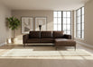 Brown leather sectional sofa on a concrete floor with a white backdrop