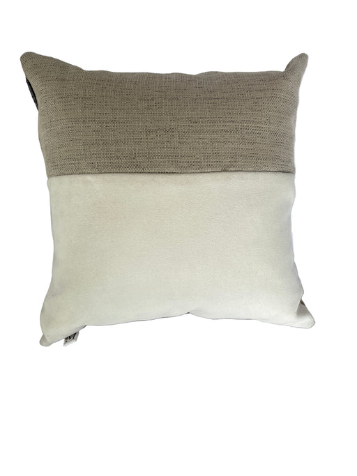 Two-tone pillow with beige and brown sections on a bed.