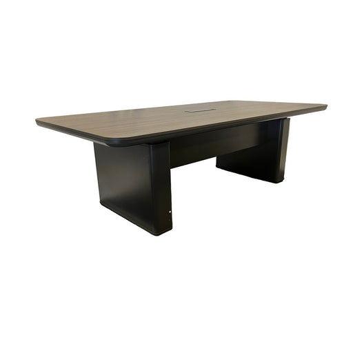 Rectangular conference table with dark brown top and black base on a gray floor with white draped fabric background