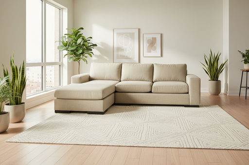 Beige sectional sofa on a gray carpet with a white wall background
