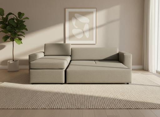 Gray sectional sofa on a gray floor with a white backdrop