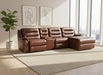Brown leather sectional sofa in a warehouse setting with a person in the background.