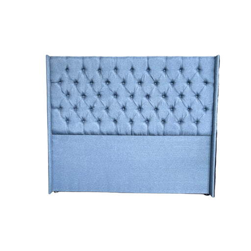 Blue tufted panel on a stand with a blurred indoor background