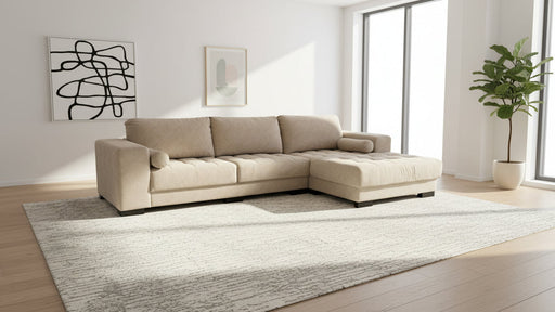 Beige sectional sofa in a modern living room with large windows and minimal decor.