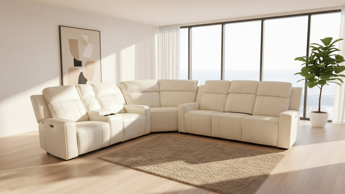 Beige sectional sofa in a modern living room with large windows and a plant.