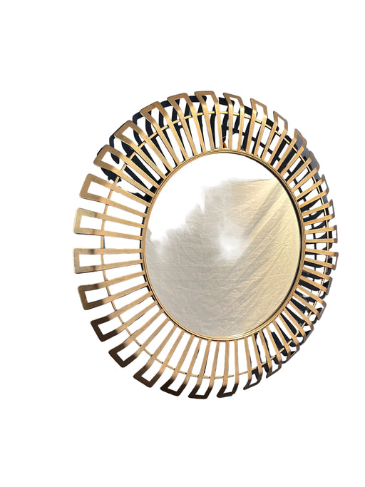 Decorative round mirror with gold frame on a gray wall