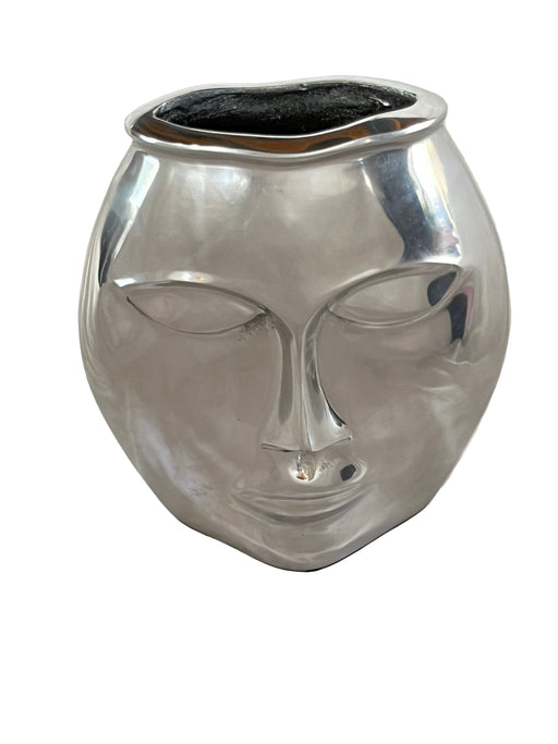 Silver decorative vase on a white fabric background