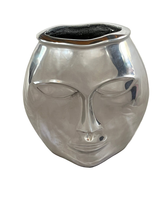 Silver decorative vase on a white fabric background