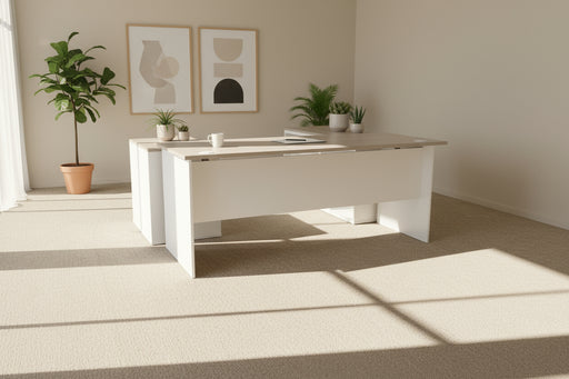 L-shaped desk with wooden top and white sides on a gray carpeted floor.