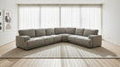 Gray sectional sofa in a large indoor space with high ceilings and exposed beams.
