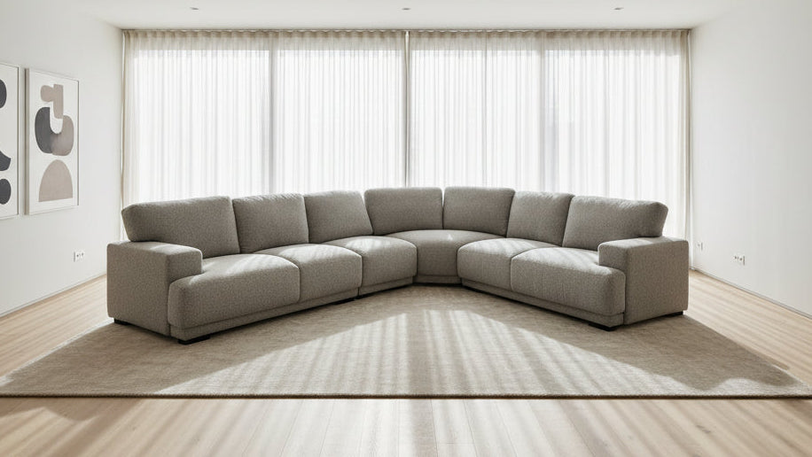 Gray sectional sofa in a large indoor space with high ceilings and exposed beams.
