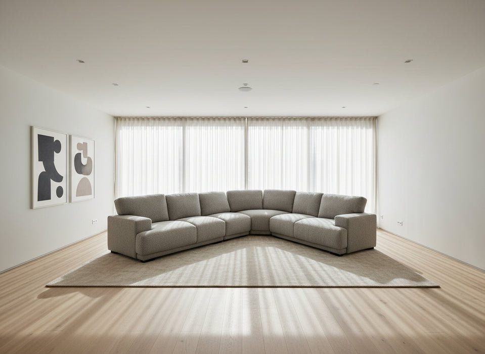 Gray sectional sofa in a large indoor space with high ceilings and exposed beams.