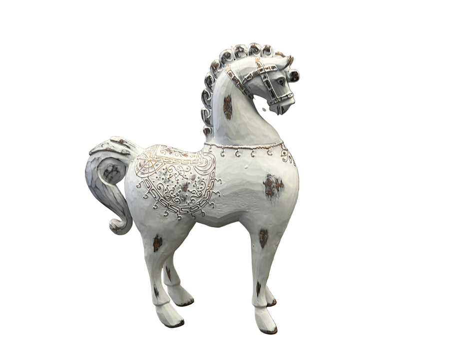 Decorative horse figurine with intricate designs on a textured white background