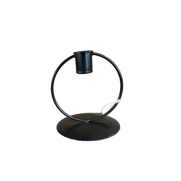 Black metal ring stand on a wooden surface with a beige textured box in the background.