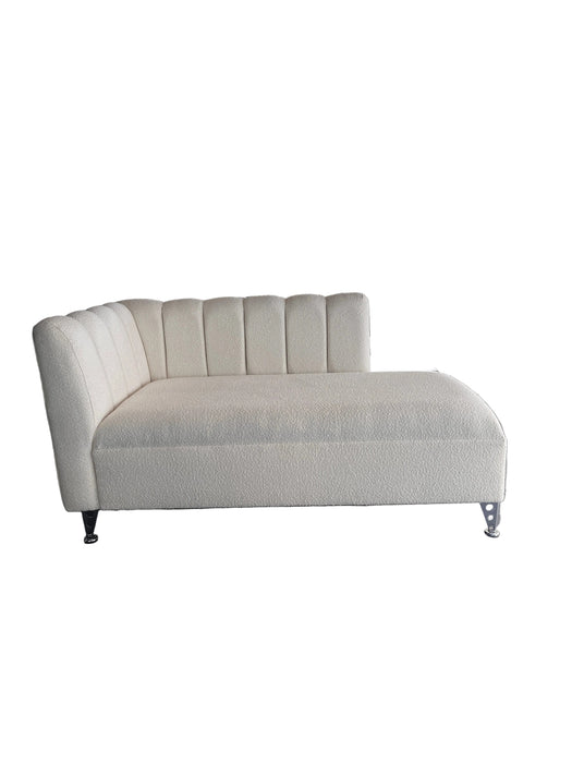 Modern white sofa against a dark wall with a glass staircase in the background