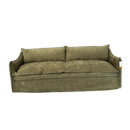 An olive green upholstered loveseat or sofa shown from an overhead angle, positioned on a gray carpet next to a white draped fabric in an indoor showroom or studio setting.