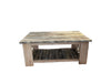 A rustic rectangular wooden coffee table with a weathered top, a lower slatted shelf, and a light natural wood frame, set against a draped white fabric backdrop.