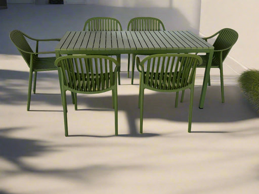 Green outdoor table and chairs set on a textured white surface
