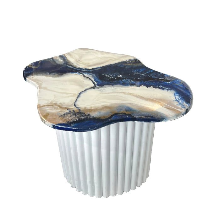 Decorative side table with blue and white marbled design on a gray carpet