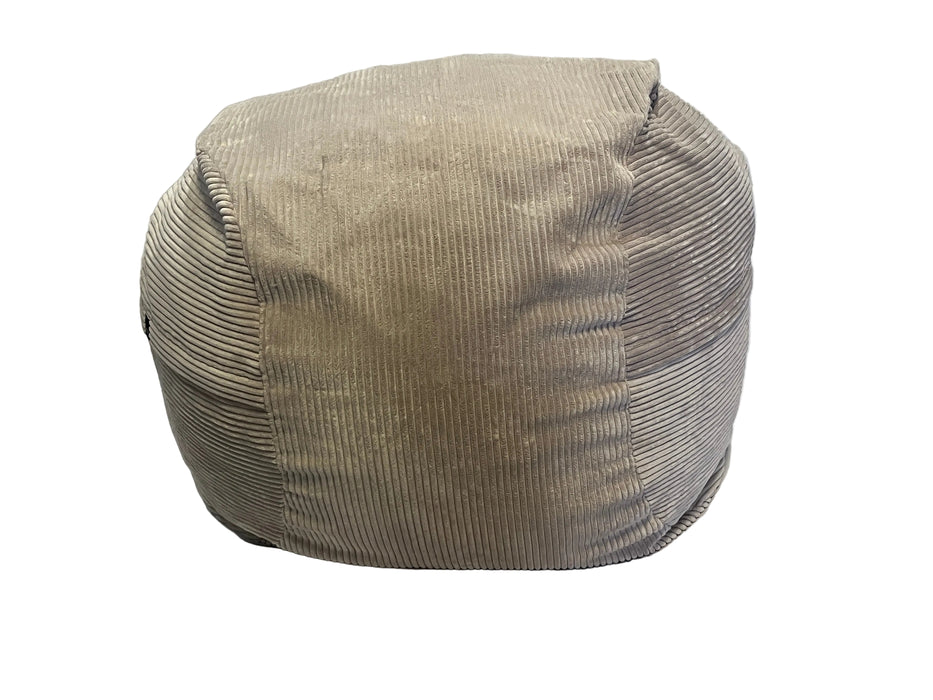 Beige corduroy ottoman on a white bedspread