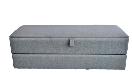 Gray rectangular box with a handle on a textured white surface