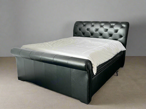 Black leather bed with white mattress against a gray wall