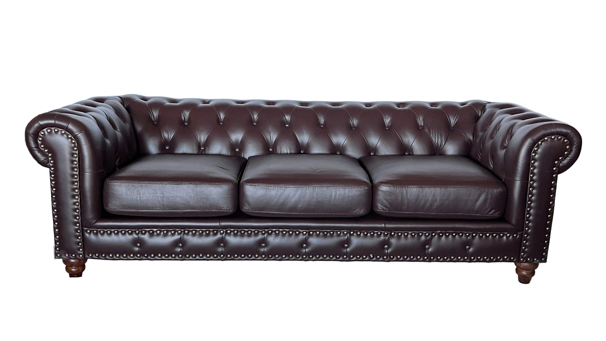 Brown leather sofa with tufted backrest and armrests on a white background