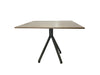 Wooden table with black metal legs on a white draped background