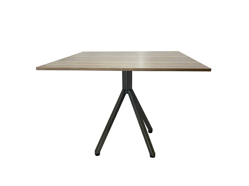 Wooden table with black metal legs on a white draped background
