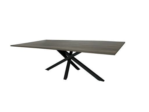 Modern dining table with wooden top and black metal legs on a white fabric-covered floor.