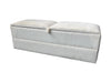 White textured ottoman with a lid on a gray floor against a white wall.
