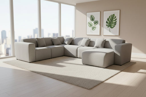 Gray sectional sofa on a gray carpet with white walls in the background