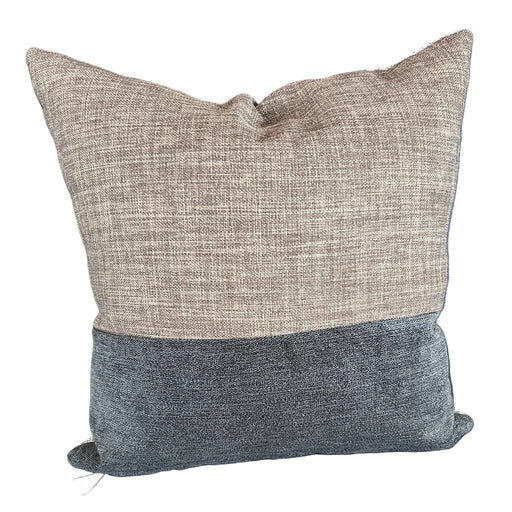 Two textured pillows on a blue sofa with a visible tag.