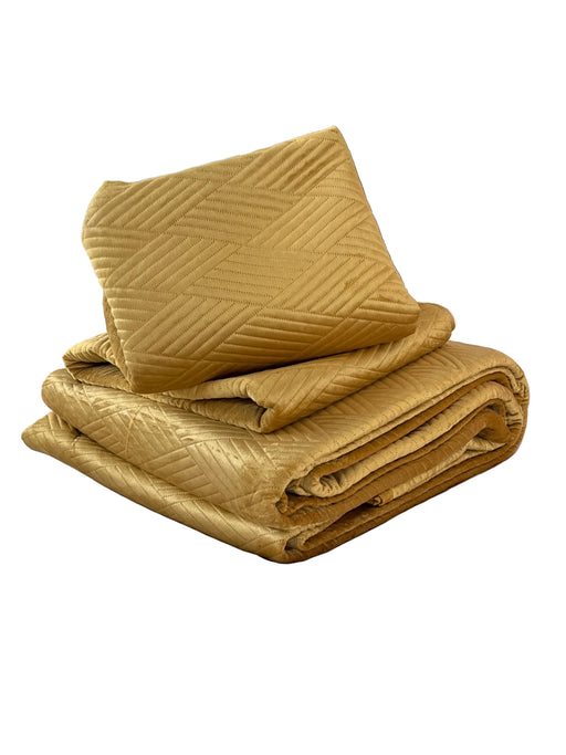 Folded mustard yellow blanket on a bed in a bedroom setting