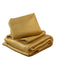Folded mustard yellow blanket on a bed in a bedroom setting
