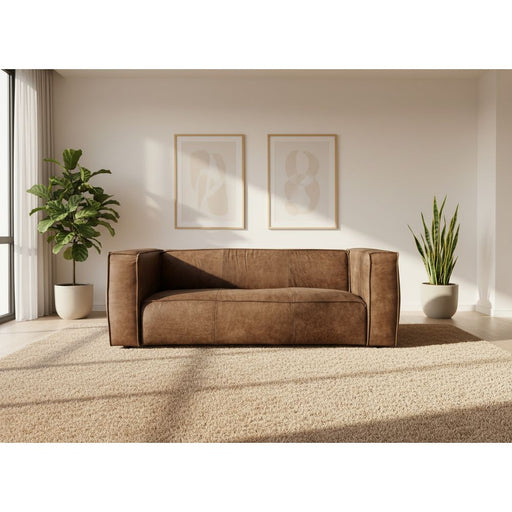 Brown sofa being set up with a white backdrop in an indoor setting