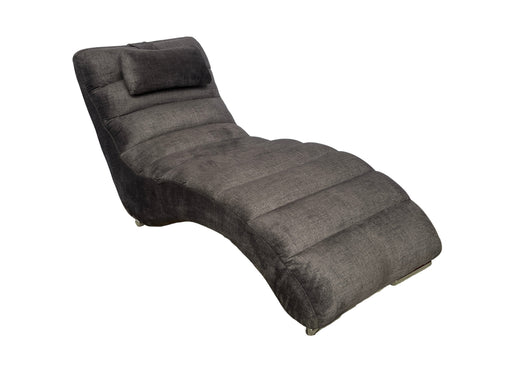 Gray lounge chair on a textured surface with a white backdrop