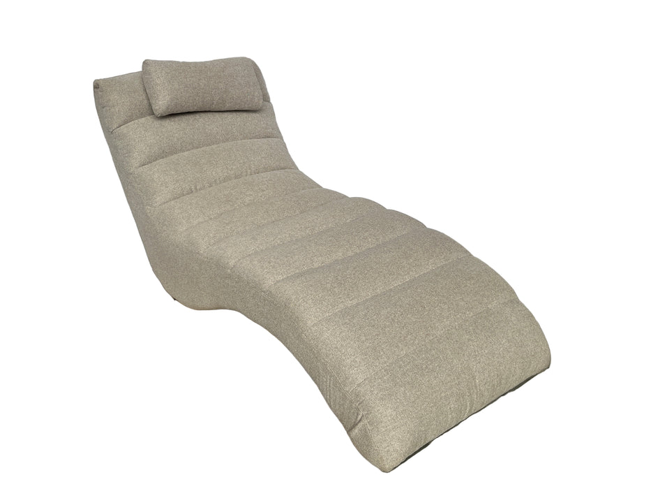 Beige lounge chair on a concrete floor with a white backdrop
